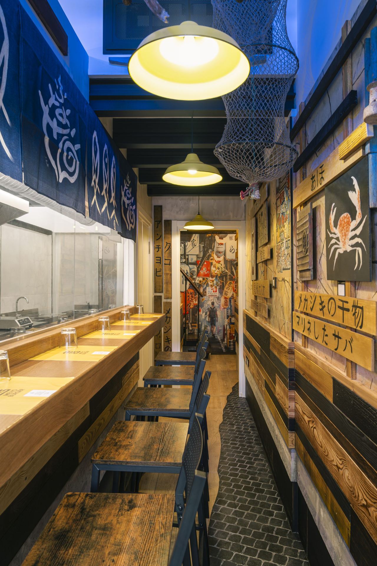 Bancone con noren blu e panchine in legno