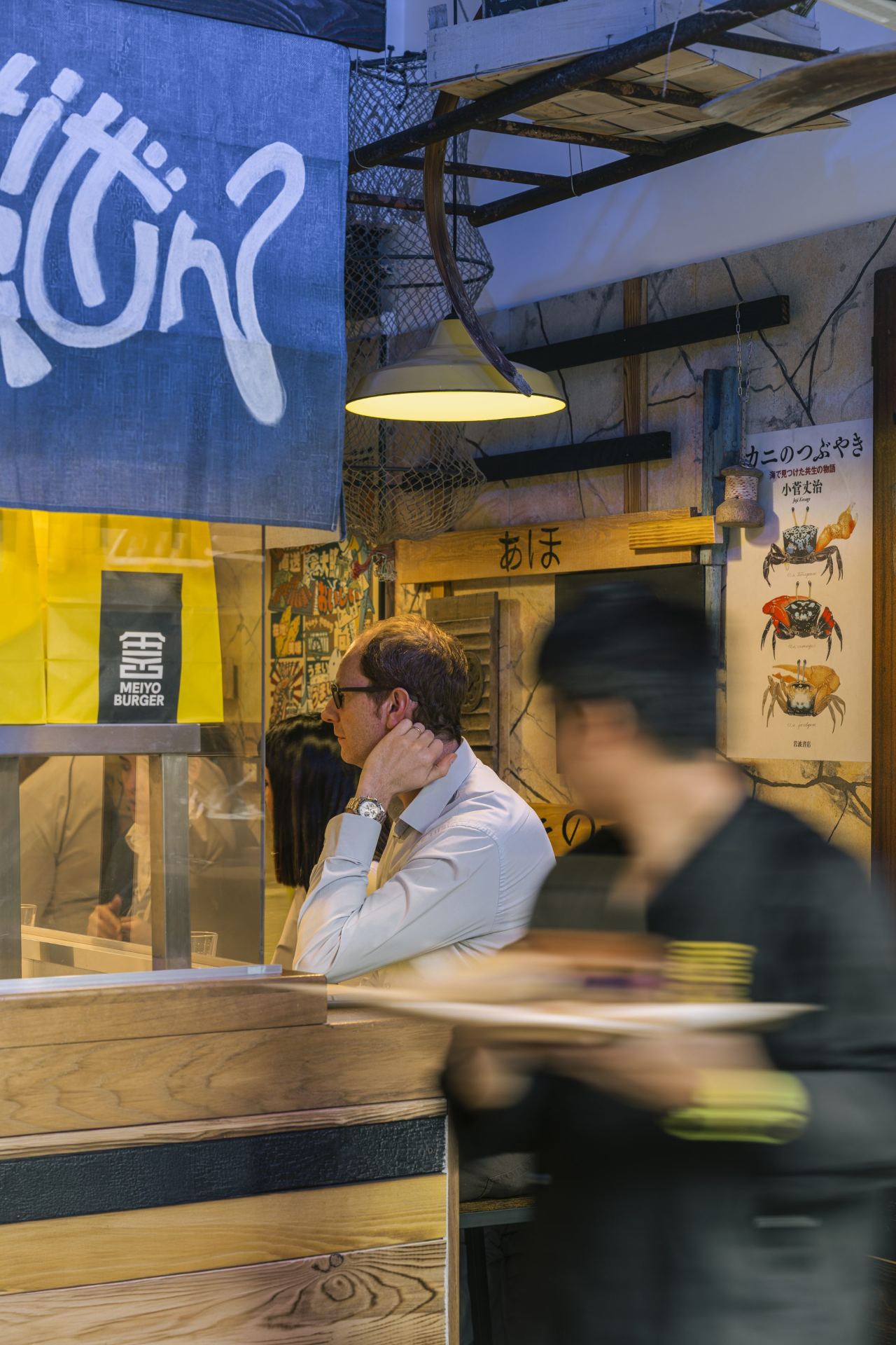 Cliente al bancone, vista attraverso il noren blu