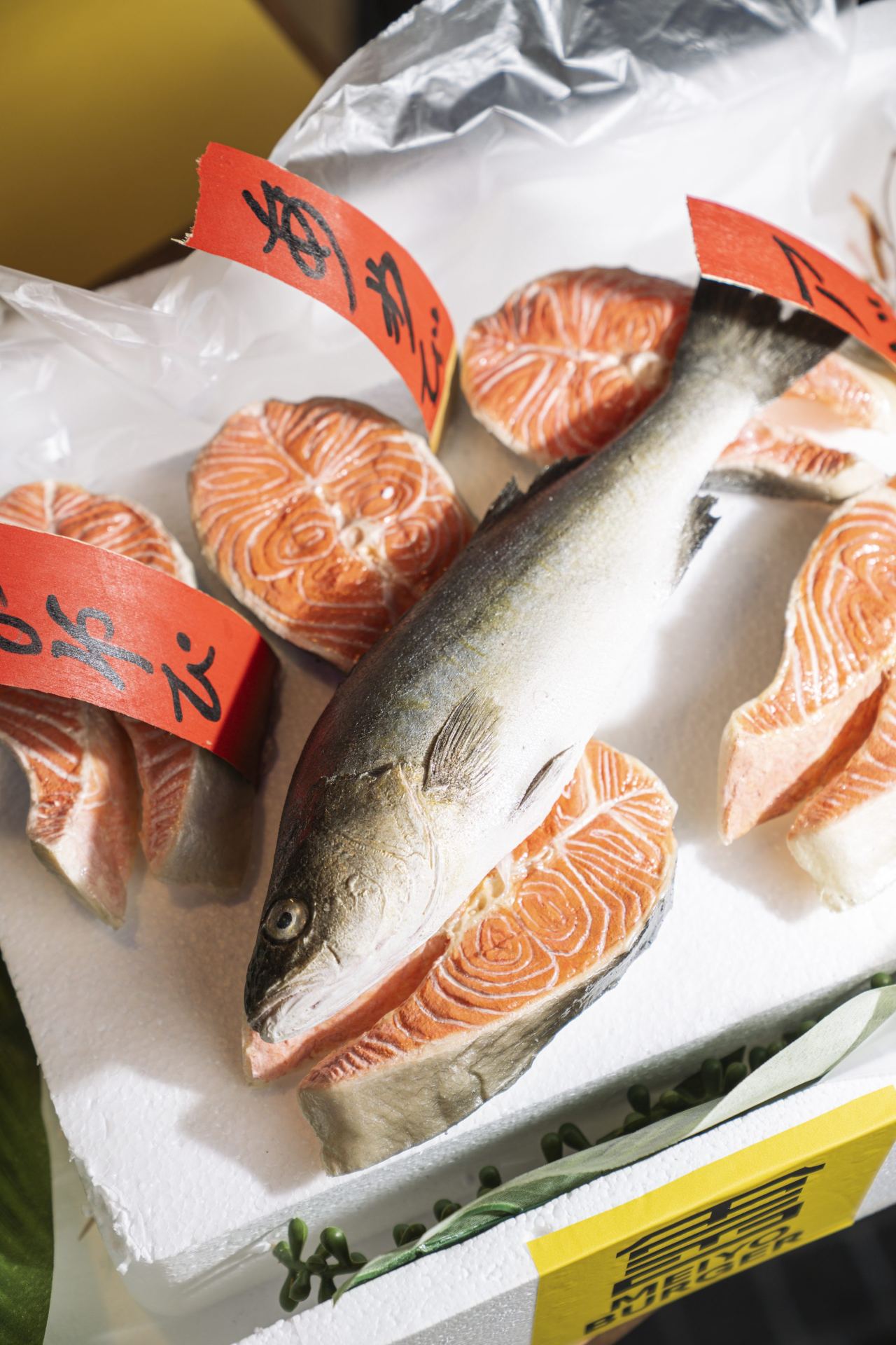 Salmone fresco con etichette rosse calligrafiche